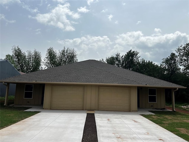 ranch-style home with roof with shingles, board and batten siding, concrete driveway, and a garage
