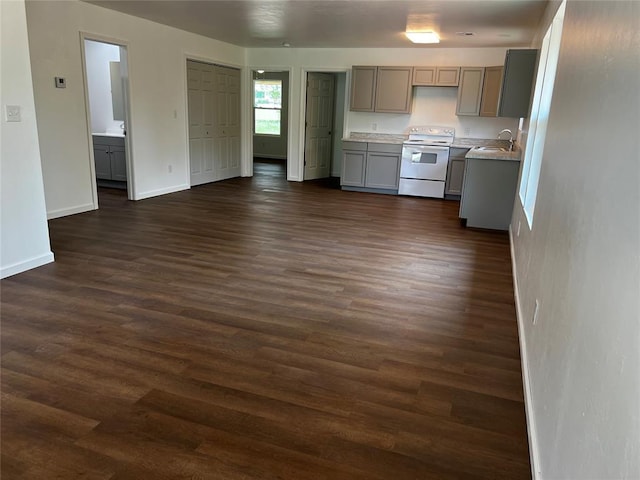 kitchen featuring dark wood finished floors, gray cabinets, electric range, light countertops, and a sink