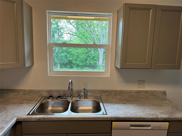 kitchen with dishwashing machine, gray cabinets, and a sink