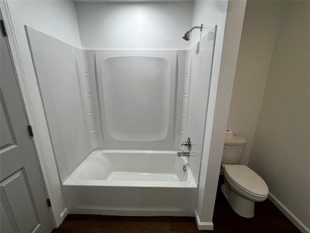bathroom with wood finished floors, toilet, shower / bath combination, and baseboards