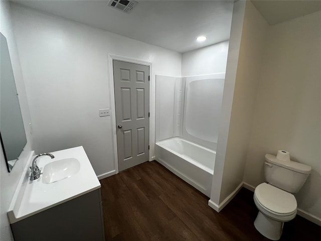 bathroom featuring vanity, toilet, visible vents, baseboards, and wood finished floors