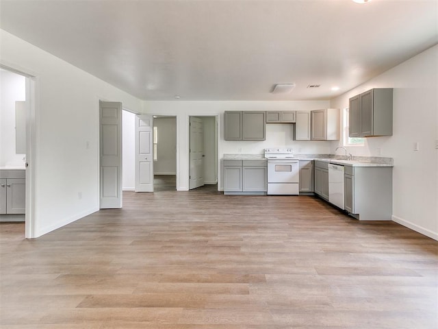 1823 E Rutgers Ave, Guthrie, OK 73044 - kitchen with a sink, white appliances, light countertops, gray cabinets, and baseboards