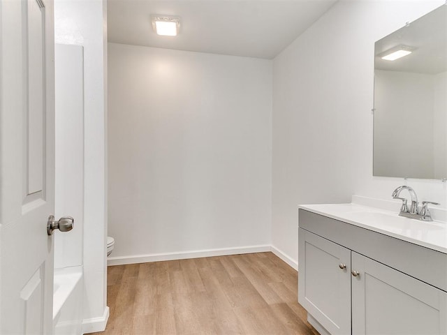 1823 E Rutgers Ave, Guthrie, OK 73044 - bathroom with vanity, wood finished floors, toilet, baseboards, and a bathtub