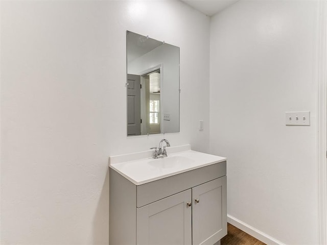 1823 E Rutgers Ave, Guthrie, OK 73044 - bathroom featuring baseboards, wood finished floors, and vanity