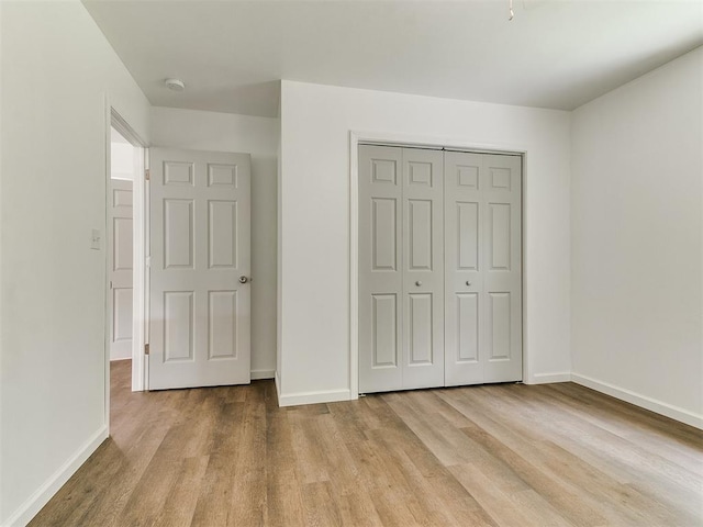 1823 E Rutgers Ave, Guthrie, OK 73044 - unfurnished bedroom featuring baseboards, a closet, and wood finished floors