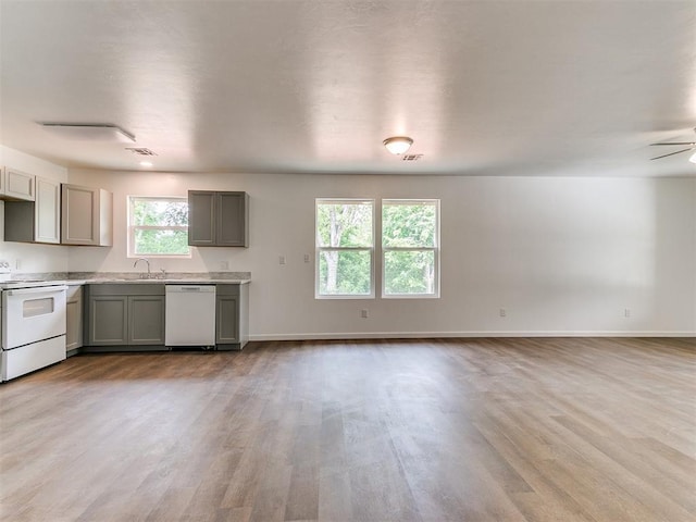 1823 E Rutgers Ave, Guthrie, OK 73044 - kitchen with a sink, white appliances, light countertops, wood finished floors, and gray cabinetry