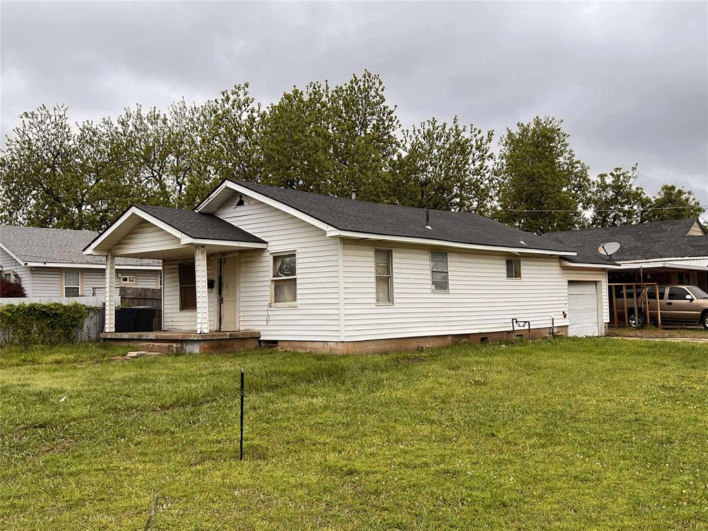 ranch-style home featuring a porch, a garage, and a front lawn