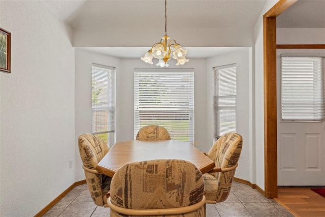 dining area featuring light tile patterned floors, a chandelier, and baseboards