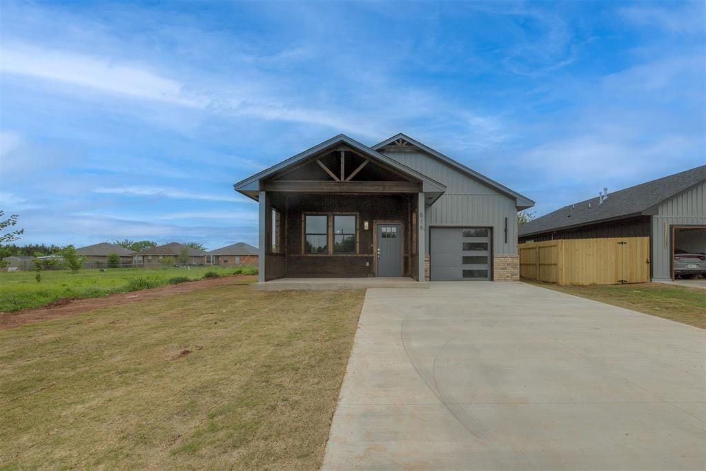 516 NW 112th St, Oklahoma City, OK 73114 - contemporary home with driveway, covered porch, a front lawn, and a garage