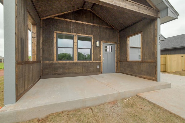 view of exterior entry with a patio area