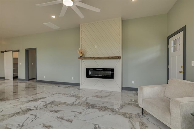 unfurnished living room featuring recessed lighting, ceiling fan, a glass covered fireplace, marble finish floor, and baseboards