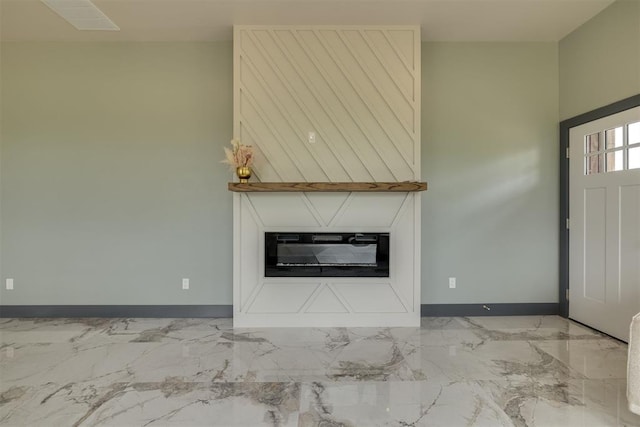 unfurnished living room featuring baseboards, a glass covered fireplace, and marble finish floor