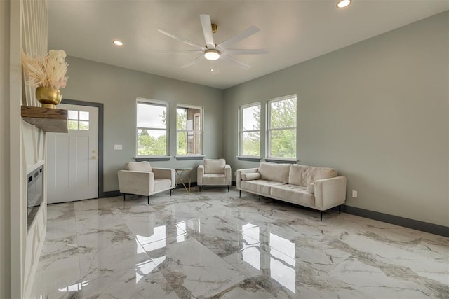 living room with baseboards, recessed lighting, ceiling fan, and marble finish floor