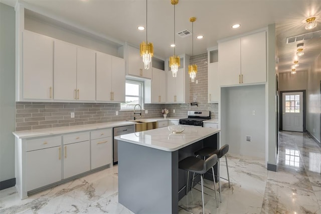kitchen featuring white cabinetry, a sink, appliances with stainless steel finishes, visible vents, and marble finish floor
