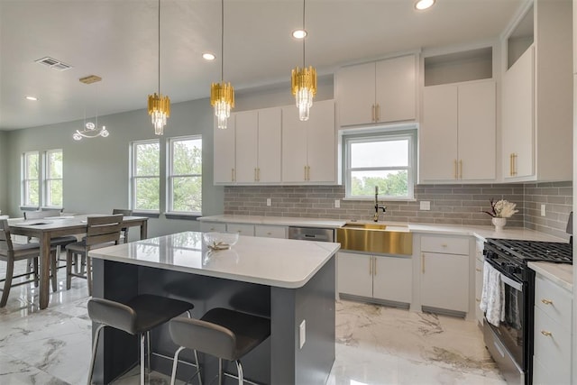 kitchen with marble finish floor, backsplash, gas stove, visible vents, and a sink