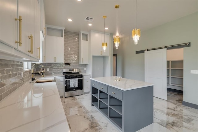 kitchen with stainless steel gas range, a barn door, decorative backsplash, open shelves, and visible vents