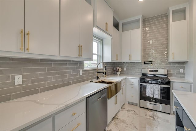 kitchen featuring white cabinetry, stainless steel appliances, marble finish floor, and a sink