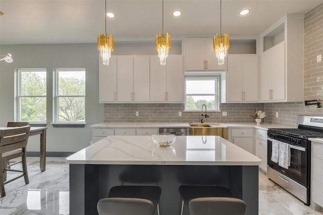 kitchen with a breakfast bar, stainless steel appliances, marble finish floor, and a sink