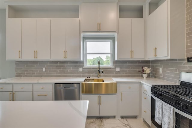 kitchen featuring a sink, stainless steel appliances, marble finish floor, backsplash, and white cabinetry