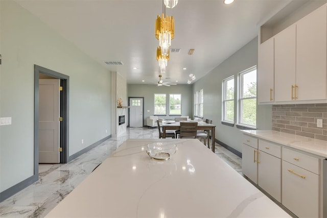 kitchen with decorative backsplash, visible vents, baseboards, recessed lighting, and marble finish floor