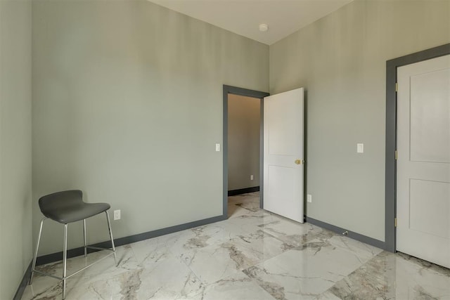 bedroom featuring marble finish floor and baseboards