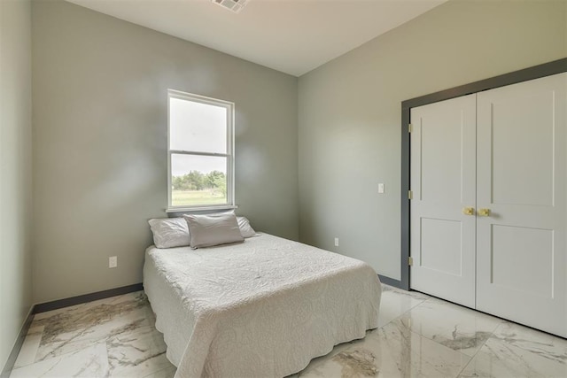 bedroom featuring marble finish floor, visible vents, a closet, and baseboards