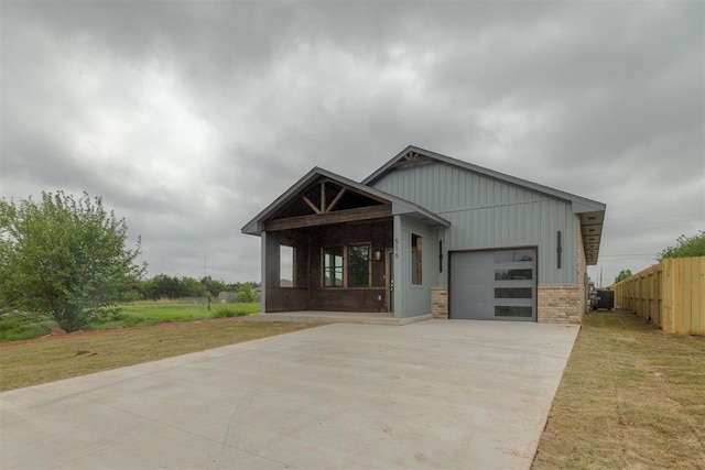 craftsman-style home with fence, concrete driveway, a front lawn, and a garage