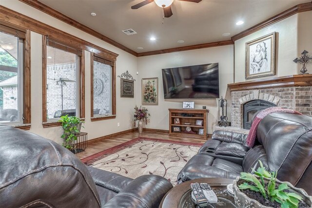1400 S May Ave, Guthrie, OK 73044 - living room featuring wood finished floors, a ceiling fan, ornamental molding, a brick fireplace, and baseboards