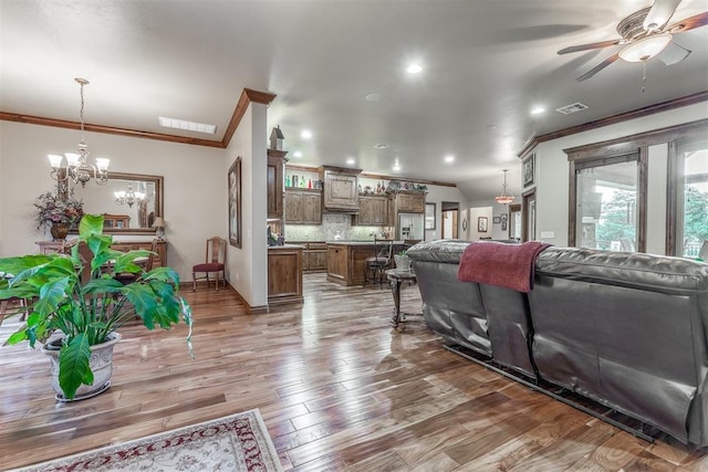1400 S May Ave, Guthrie, OK 73044 - living room with crown molding, a ceiling fan, a chandelier, wood finished floors, and recessed lighting