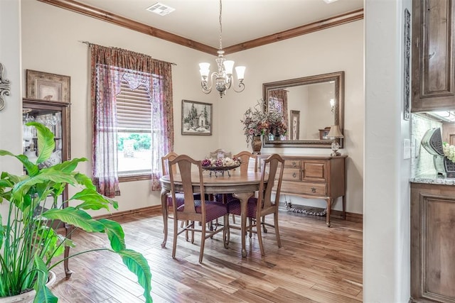 1400 S May Ave, Guthrie, OK 73044 - dining space featuring crown molding, a chandelier, light wood-type flooring, and baseboards