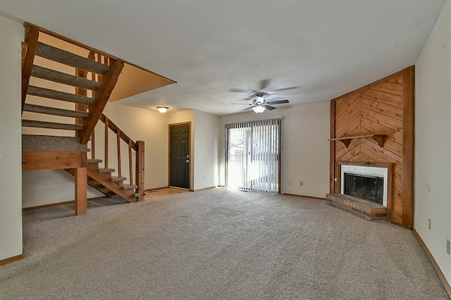 unfurnished living room featuring a brick fireplace, stairway, carpet floors, and baseboards