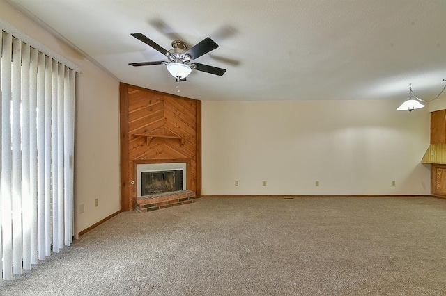 unfurnished living room featuring light colored carpet, a ceiling fan, baseboards, and a brick fireplace