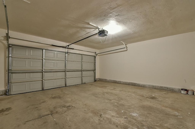 garage featuring a garage door opener and baseboards