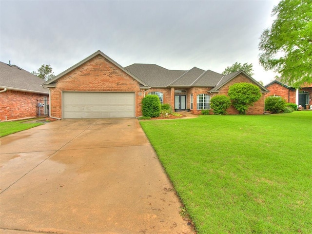 ranch-style home featuring a garage, driveway, a front lawn, and brick siding