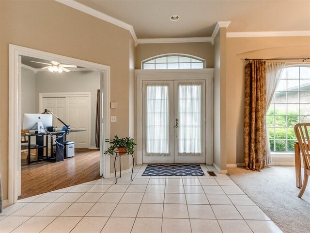 foyer featuring light tile patterned floors, baseboards, ornamental molding, and french doors