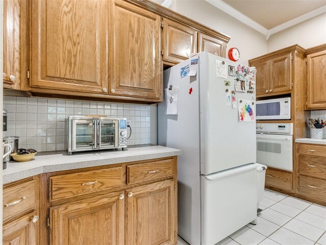kitchen featuring white appliances, light countertops, decorative backsplash, and a toaster