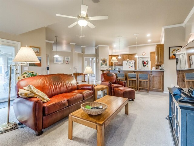 living room featuring light colored carpet, ornamental molding, a ceiling fan, and a wealth of natural light