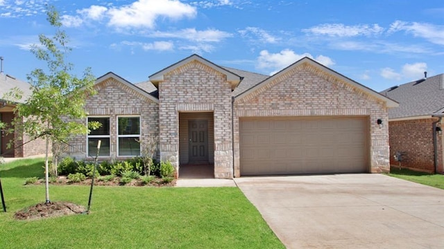 view of front of house featuring a front yard, driveway, a garage, and brick siding