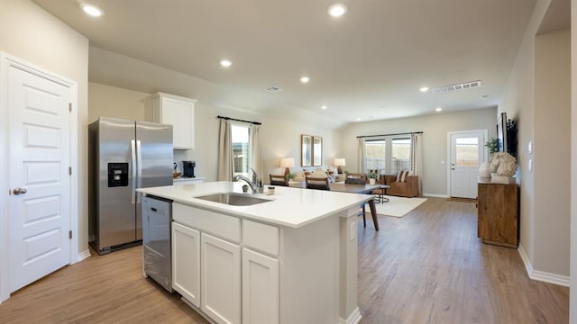kitchen with light wood-type flooring, open floor plan, appliances with stainless steel finishes, and a sink