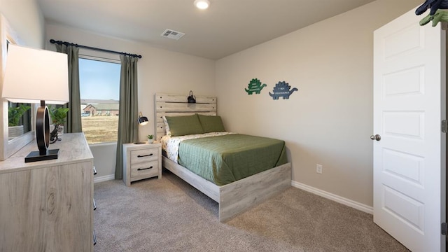 bedroom featuring visible vents, light colored carpet, and baseboards