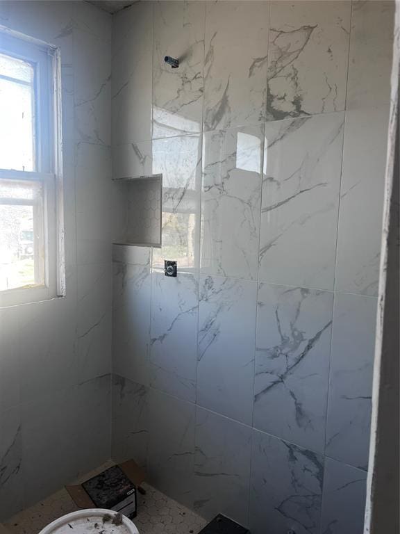 full bath with a tile shower and plenty of natural light