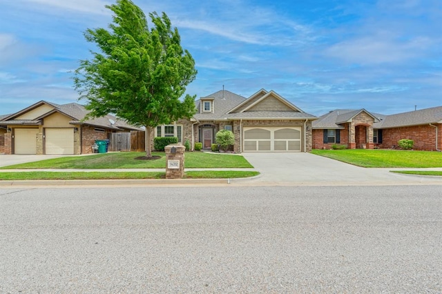 view of front facade featuring a garage, fence, a front yard, brick siding, and driveway
