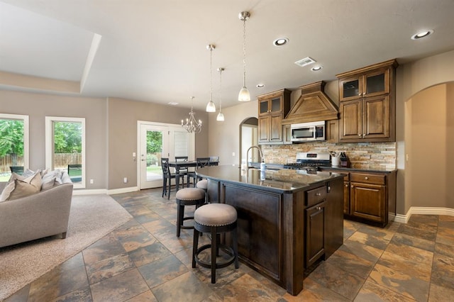 kitchen featuring visible vents, baseboards, arched walkways, appliances with stainless steel finishes, and backsplash