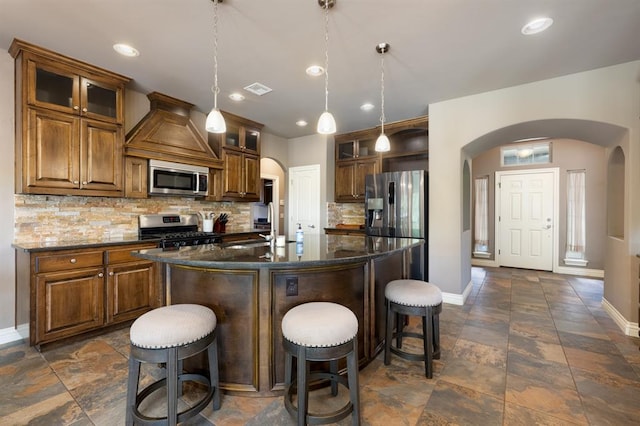 kitchen with arched walkways, baseboards, backsplash, and appliances with stainless steel finishes