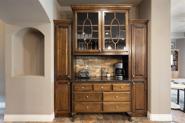 bar featuring baseboards and backsplash