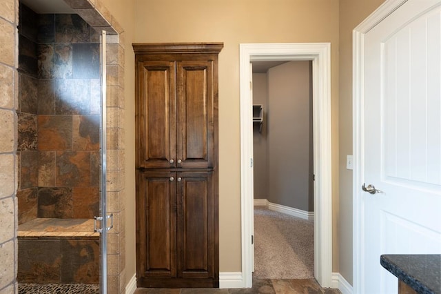 full bath with baseboards and a stall shower