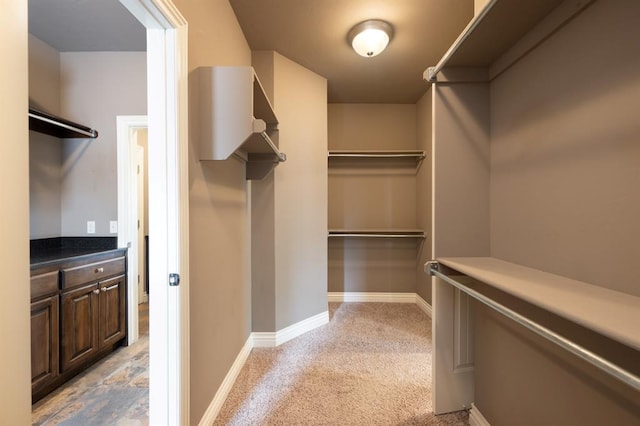 spacious closet featuring light colored carpet