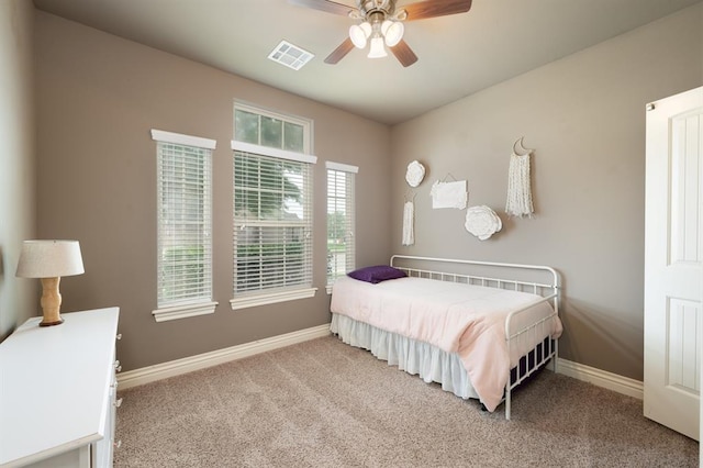carpeted bedroom with visible vents, baseboards, and ceiling fan