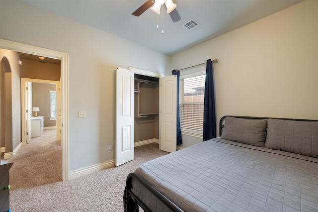 bedroom featuring carpet flooring, arched walkways, visible vents, and multiple windows