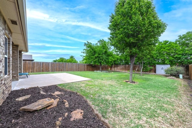 view of yard with a patio, an outbuilding, a fenced backyard, and a shed